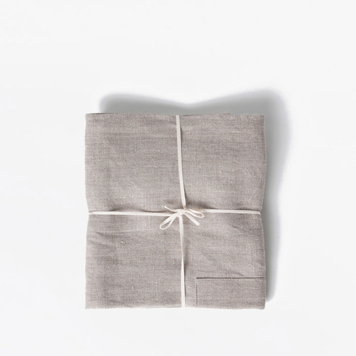 Field Company linen apron folded flat and tied with cotton string, studio shot