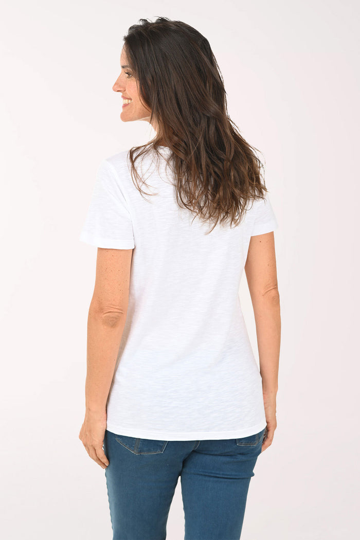 Woman wearing a white top with multi colored hearts