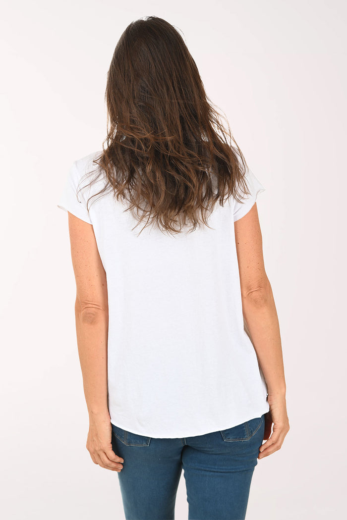 Woman wearing a white t-shirt with shoe designs on a plain background