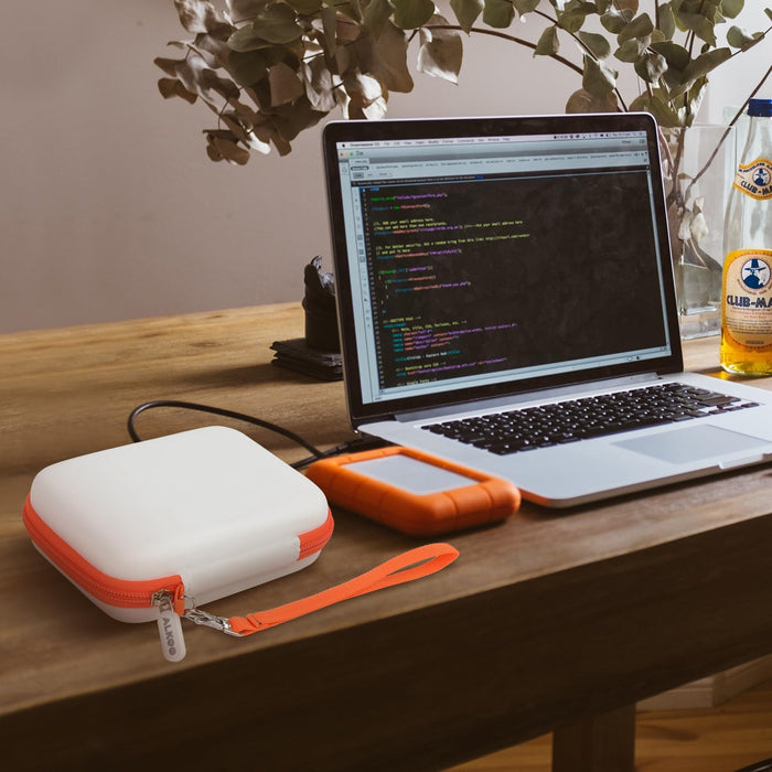 Gray and orange hard drive case beside a LaCie Rugged Mini drive connected to a laptop