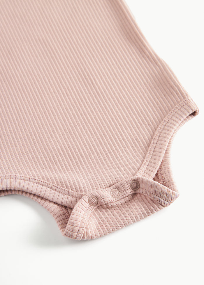 Detail of snaps at leg opening on pink baby bodysuit