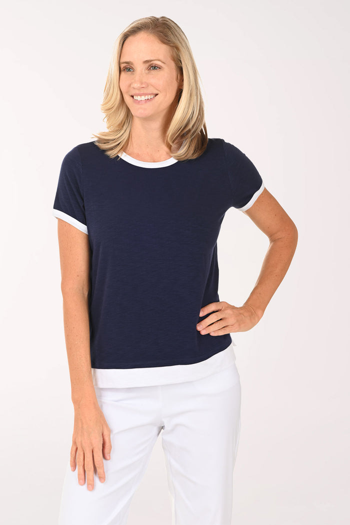 Woman wearing a navy blue t-shirt with white trim on a white background