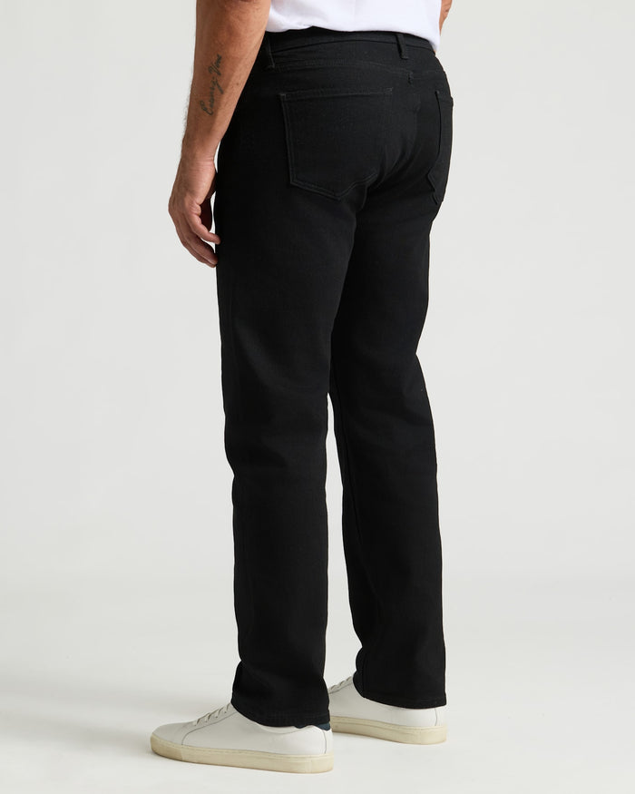 Black Wash Straight Authentic Denim Jeans viewed from the rear with sneakers.