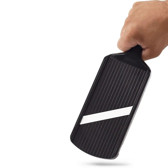 Hand holding a black ceramic blade slicer on a white background.