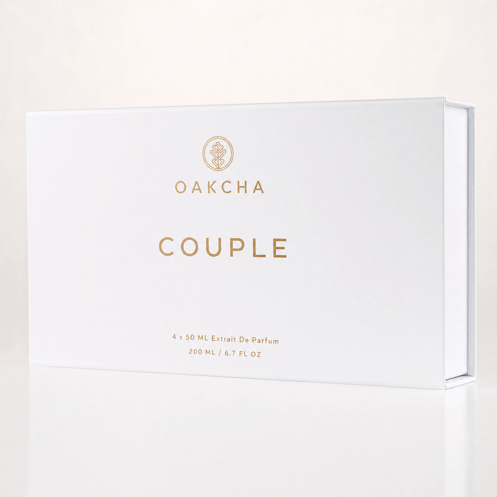 Front view of Couple Set gift box showcasing white matte packaging with gold OAKCHA logo and COUPLE lettering on a pale reflective background