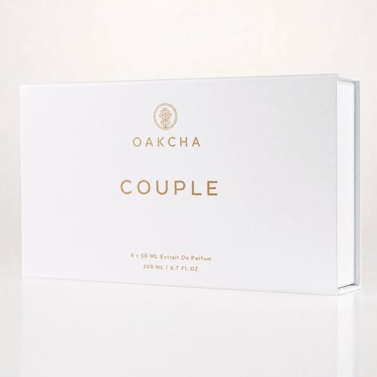 Front view of Couple Set gift box showcasing white matte packaging with gold OAKCHA logo and COUPLE lettering on a pale reflective background