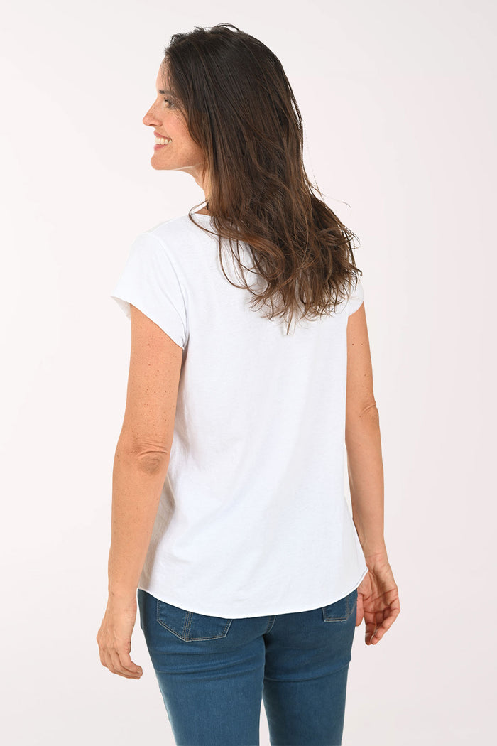 Woman wearing a white t-shirt with dog design on a plain background
