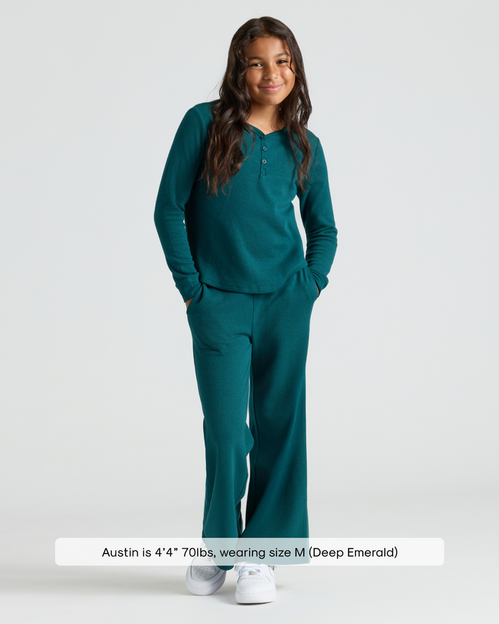 Child in Girls Deep Emerald Long Sleeve Boxy Waffle Henley and pants.