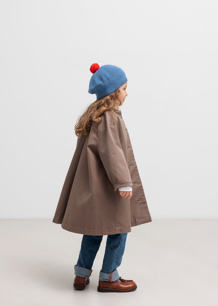 Children with blue hat wearing khaki chino coat seen from behind