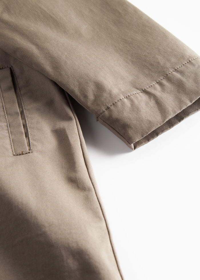 Detail shot of sleeve and pocket on khaki chino coat