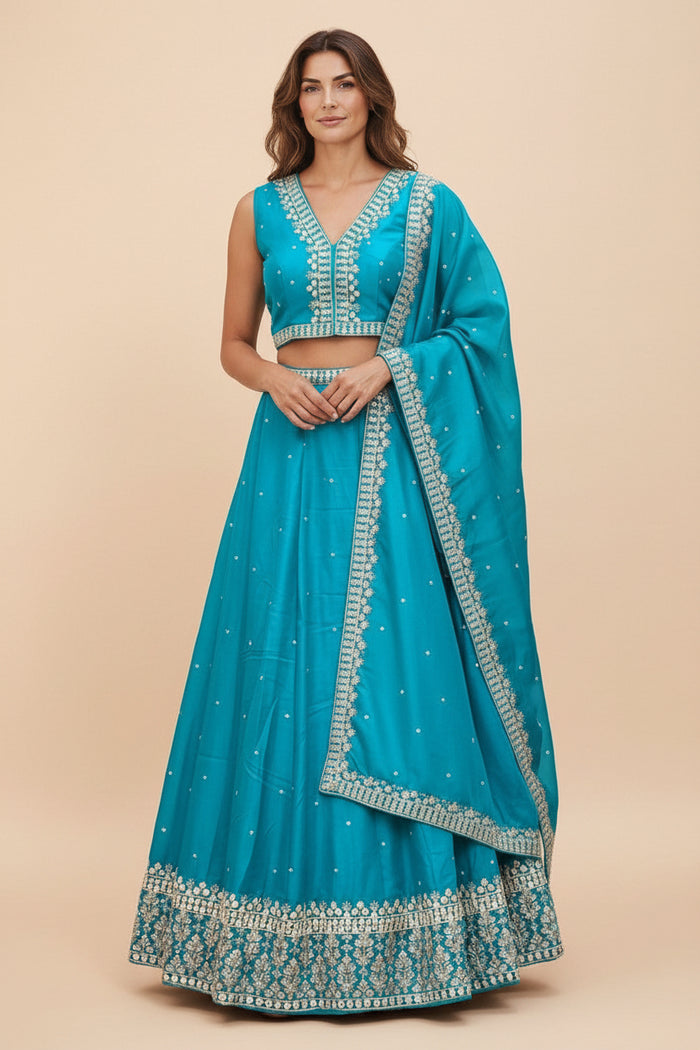 Model wearing a turquoise Kurti Connection USA lehenga choli set with silver embroidery and matching dupatta