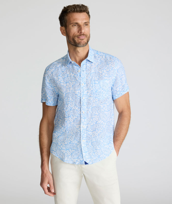 Model is wearing UNTUCKit Turner short sleeve linen shirt in light blue print.