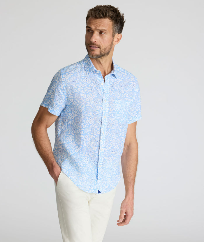 Model is wearing UNTUCKit Turner short sleeve linen shirt in light blue print.