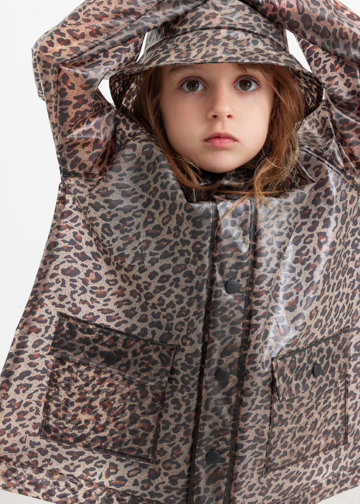 Child wearing leopard print raincoat and rain hat