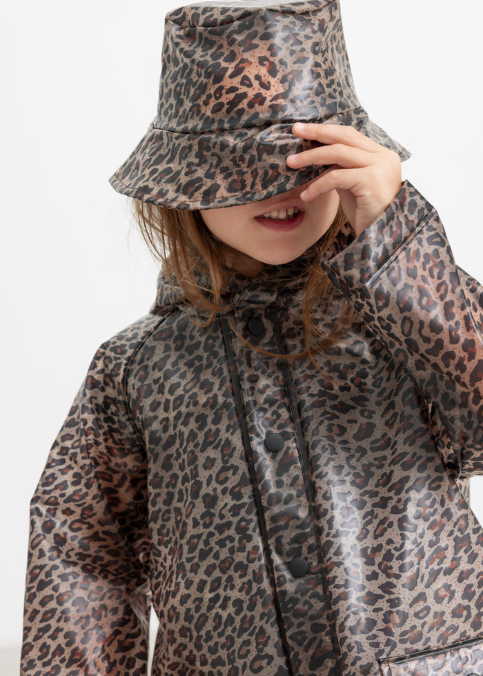 Child wearing leopard print raincoat and rain hat