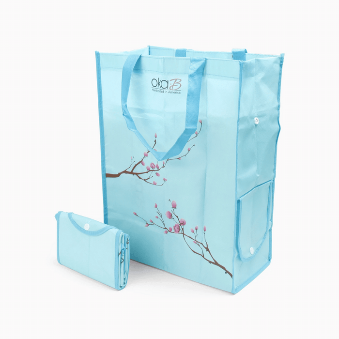 Oka-B Reusable Shopping Bag | Oka-B in light blue with pink floral branch design, shown both open and folded for compact storage.