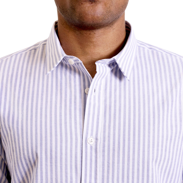 close up view of the pointed collar and neck area of soft blue and white cotton fabric button up shirt showing the vertical business pattern of the shirt. Worn by a black male model. The top buttons are undone