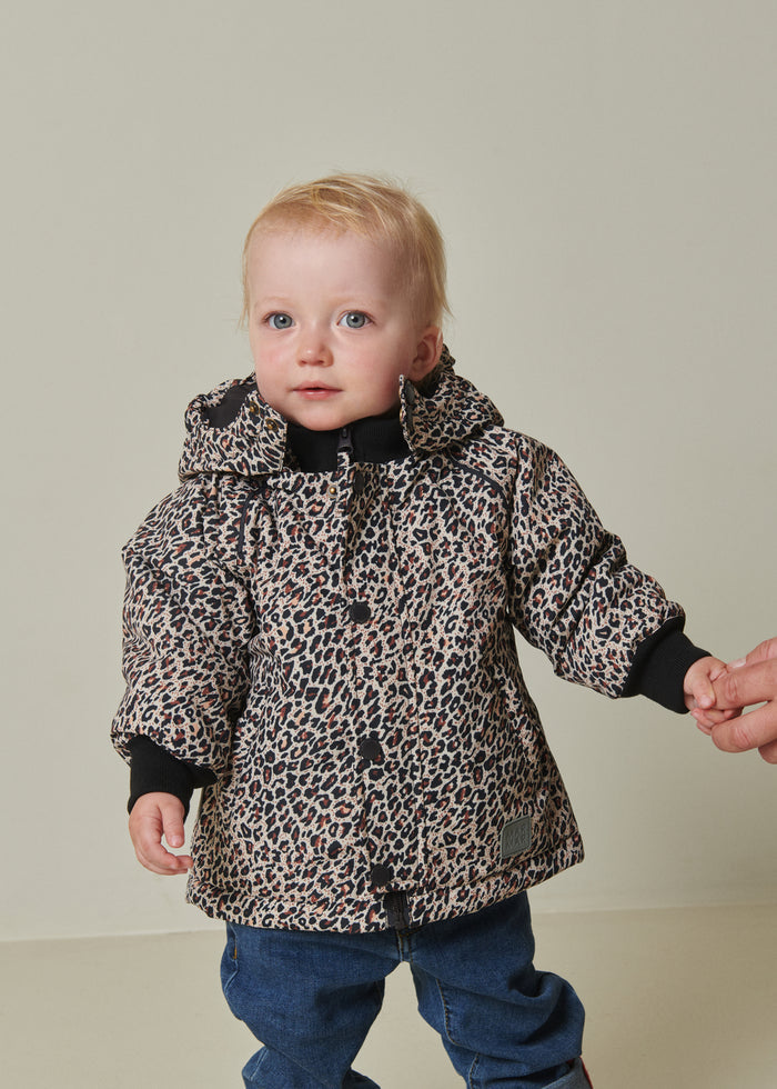 Børnevinterjakke med leopardmønster og hætte samt mørke manchetter, model iført