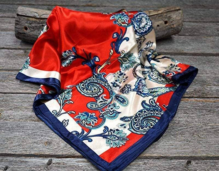 Red, white, and blue patterned silk scarf on wood.