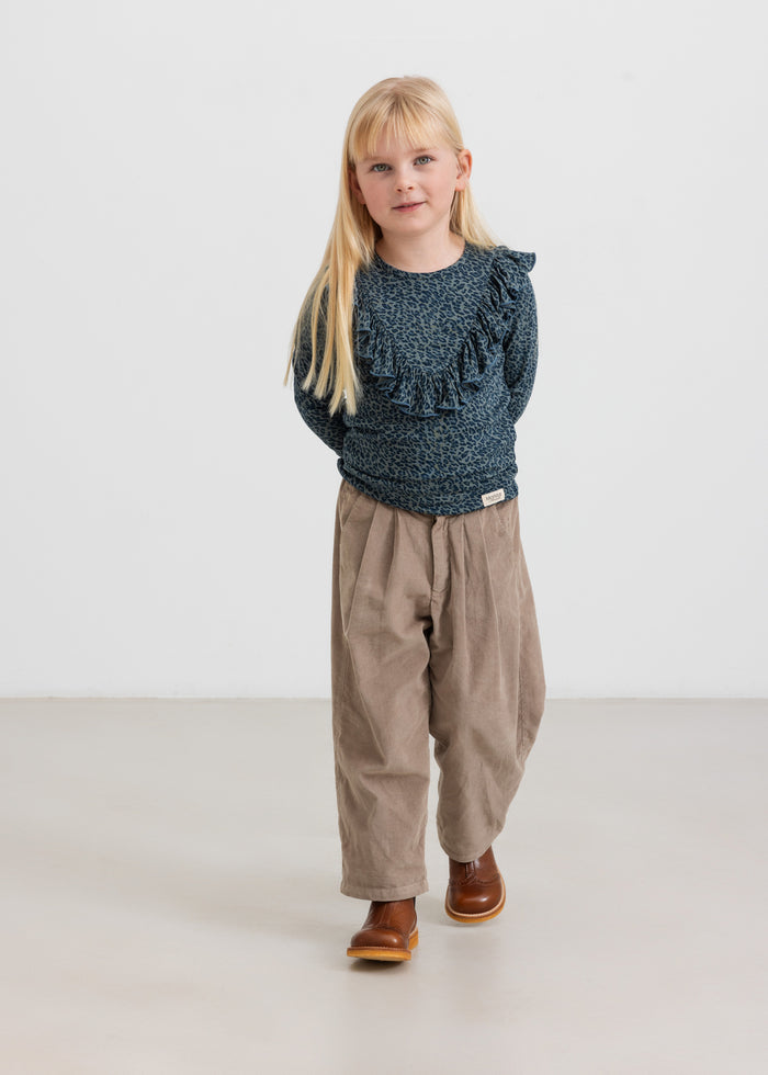 Girl wearing beige baby corduroy pants and dark blue blouse
