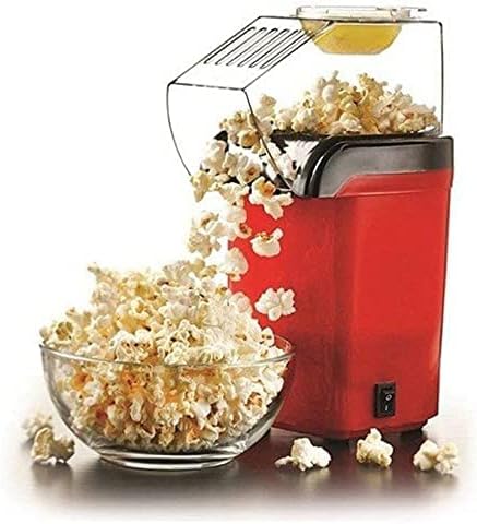 Red popcorn maker with open clear top, black handle area, beside glass bowl of popcorn