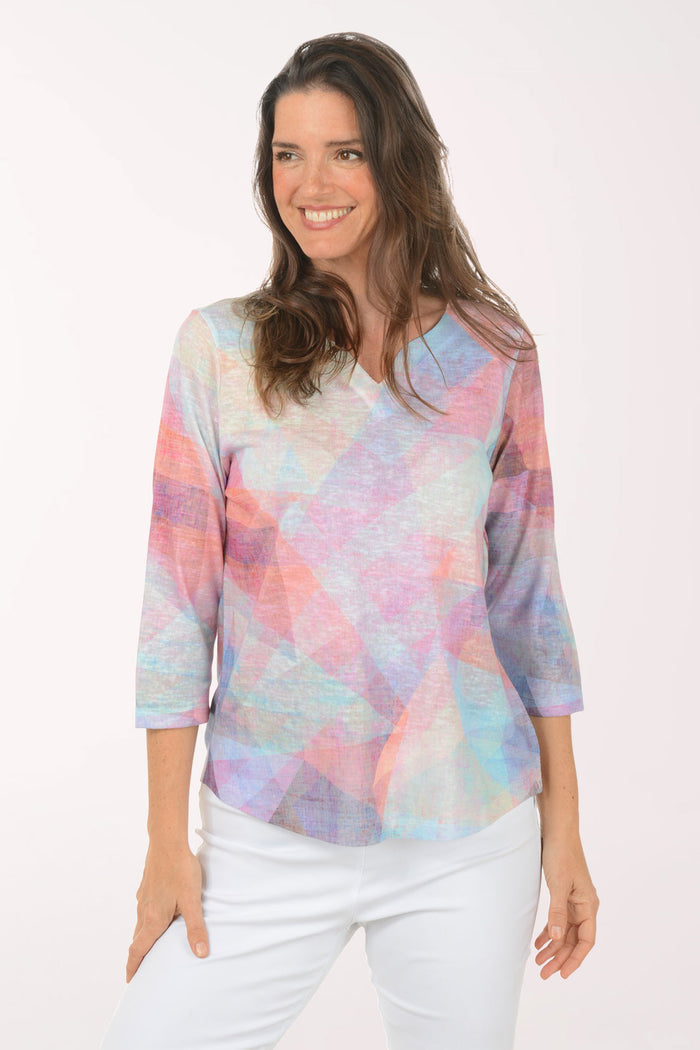 Woman wearing a multicolored v-neck 3/4 sleeve top.