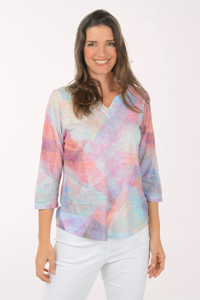 Woman wearing a multicolored v-neck 3/4 sleeve top.