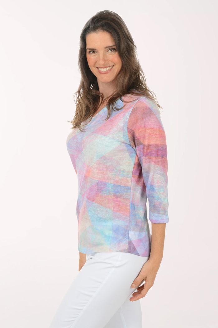 Woman wearing a multicolored v-neck 3/4 sleeve top.