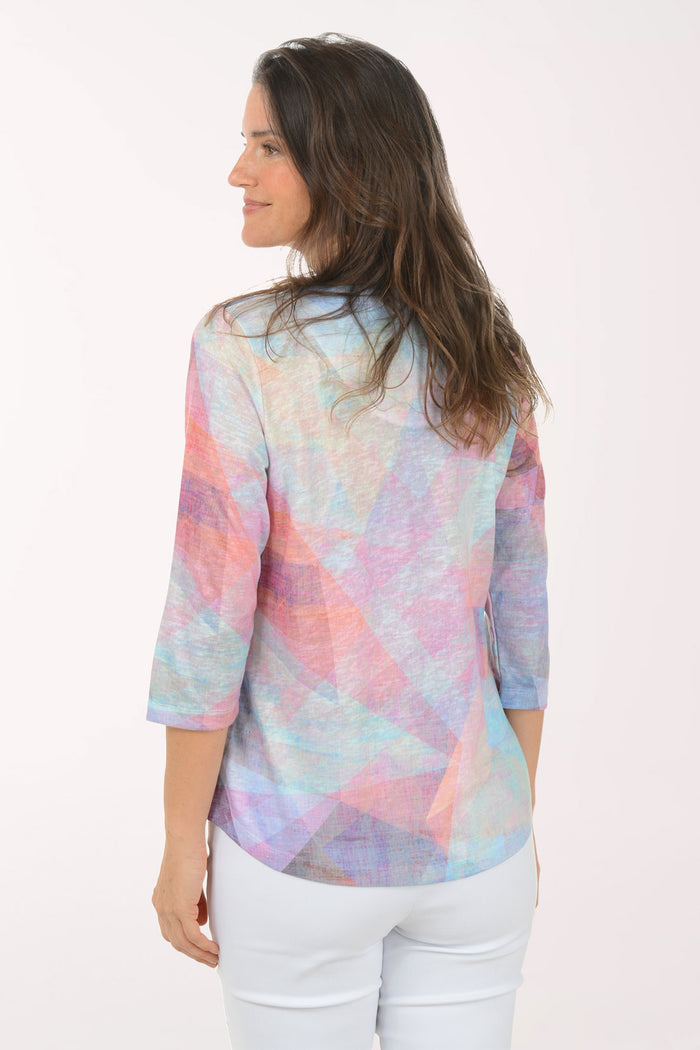 Woman wearing a multicolored v-neck 3/4 sleeve top.