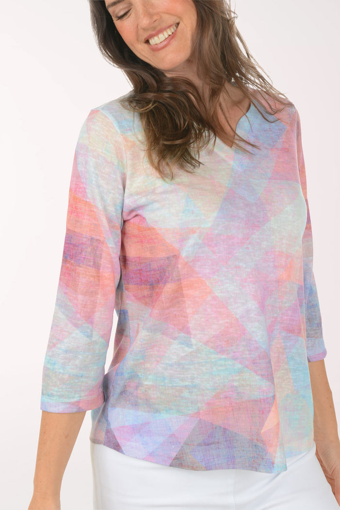 Woman wearing a multicolored v-neck 3/4 sleeve top.