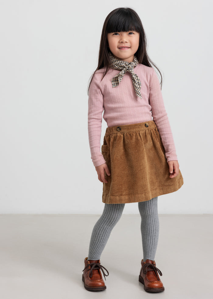 Girl wearing brown velvet skirt and pink blouse