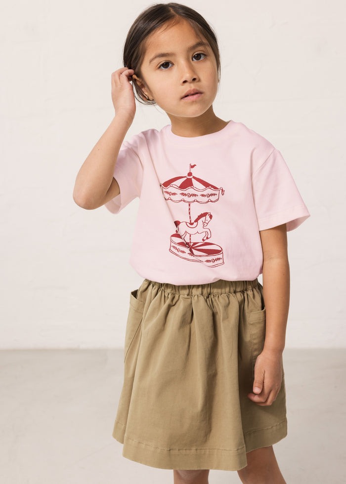 Wearing a green chino bottom and a bright red t-shirt.
