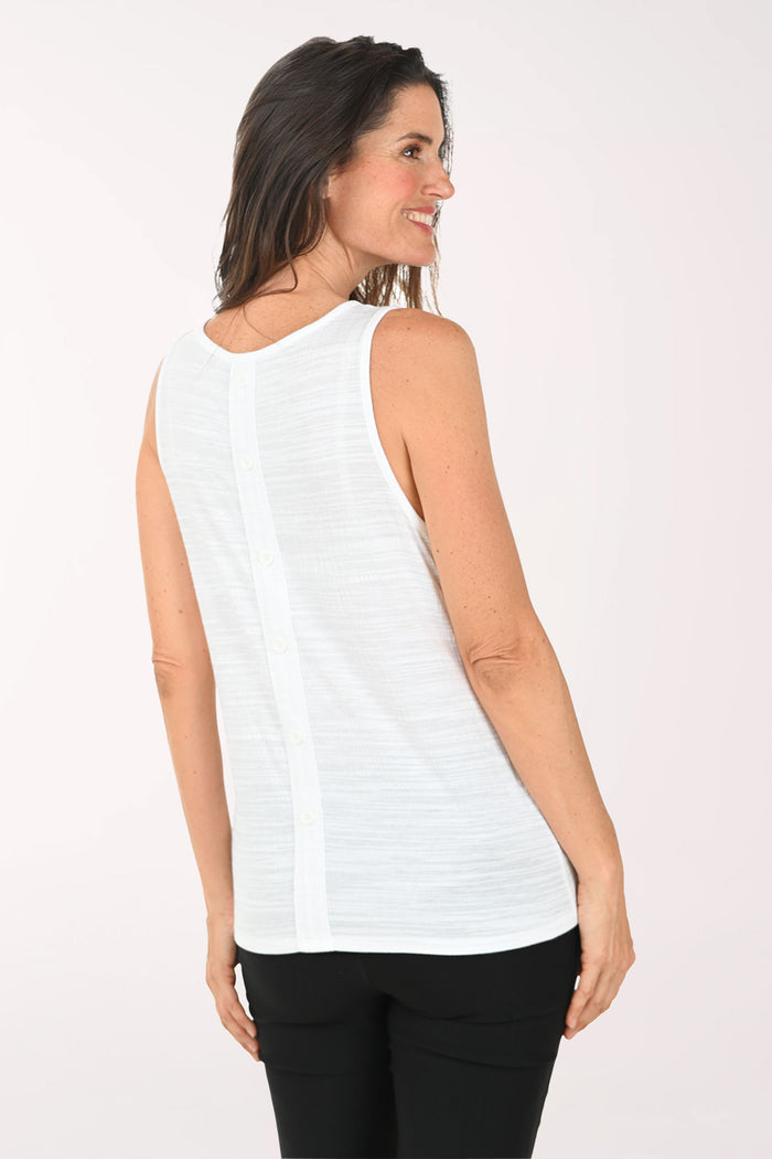 Woman wearing a white sleeveless top and black pants on a white background