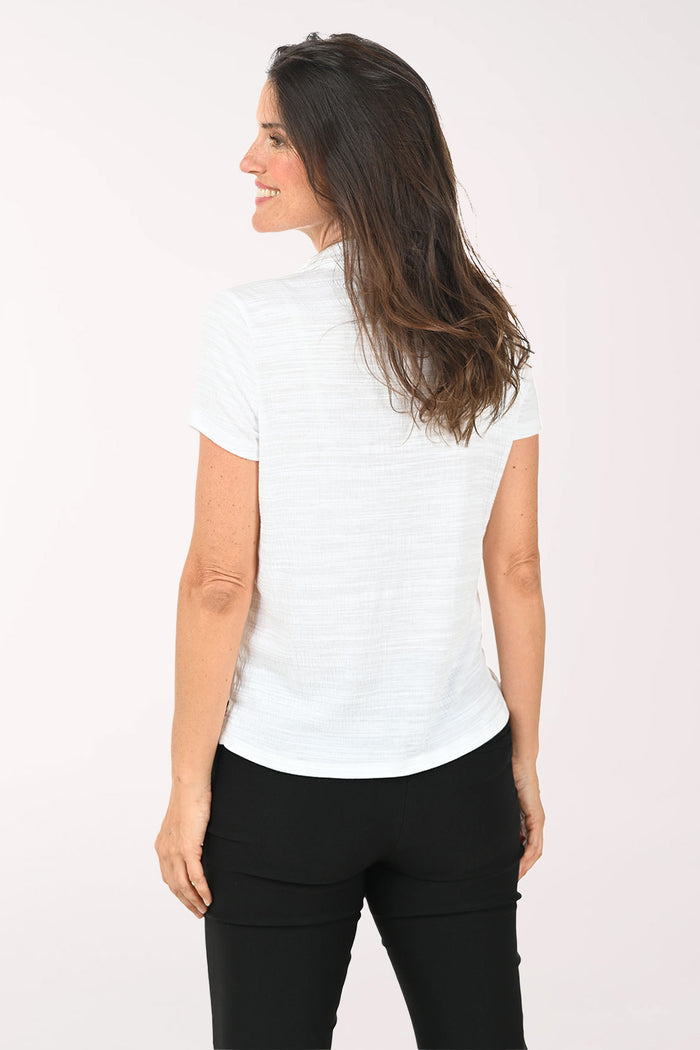 Woman wearing a white blouse and black pants on a white background