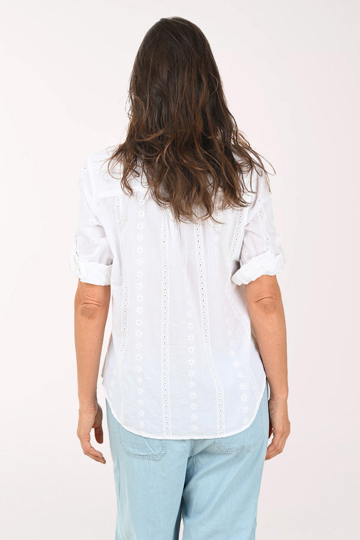Woman wearing a white roll sleeve top.
