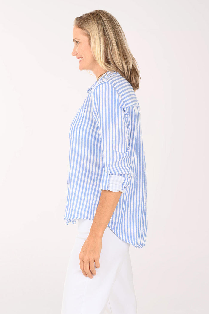 Woman wearing a blue and white striped roll sleeve shirt
