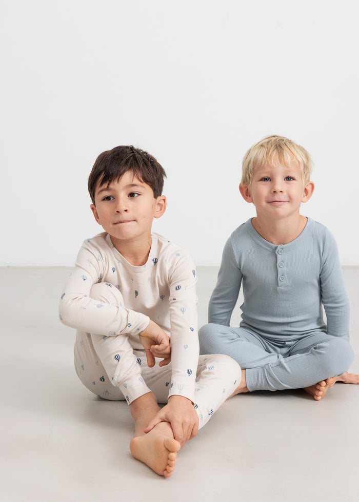 Lyseblå langærmet T-shirt med tre knapper foran, vist på barn