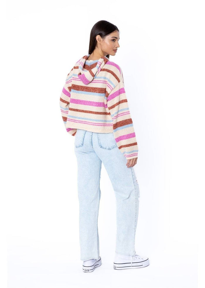 back of Woman wearing a striped sweater and light blue jeans on a white background