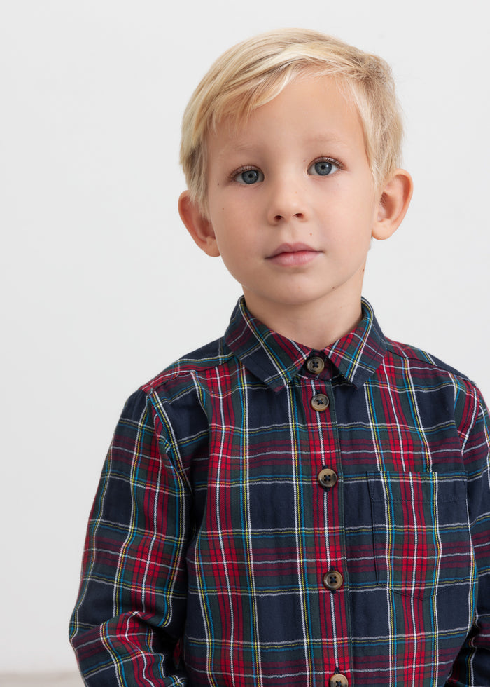 Boy wearing dark blue and red checkered Christmas button-up shirt for kids