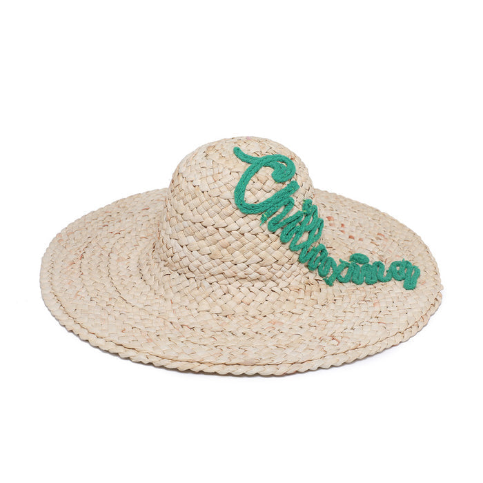 Wide brim raffia hat with “chillaxing” script detail wholesale